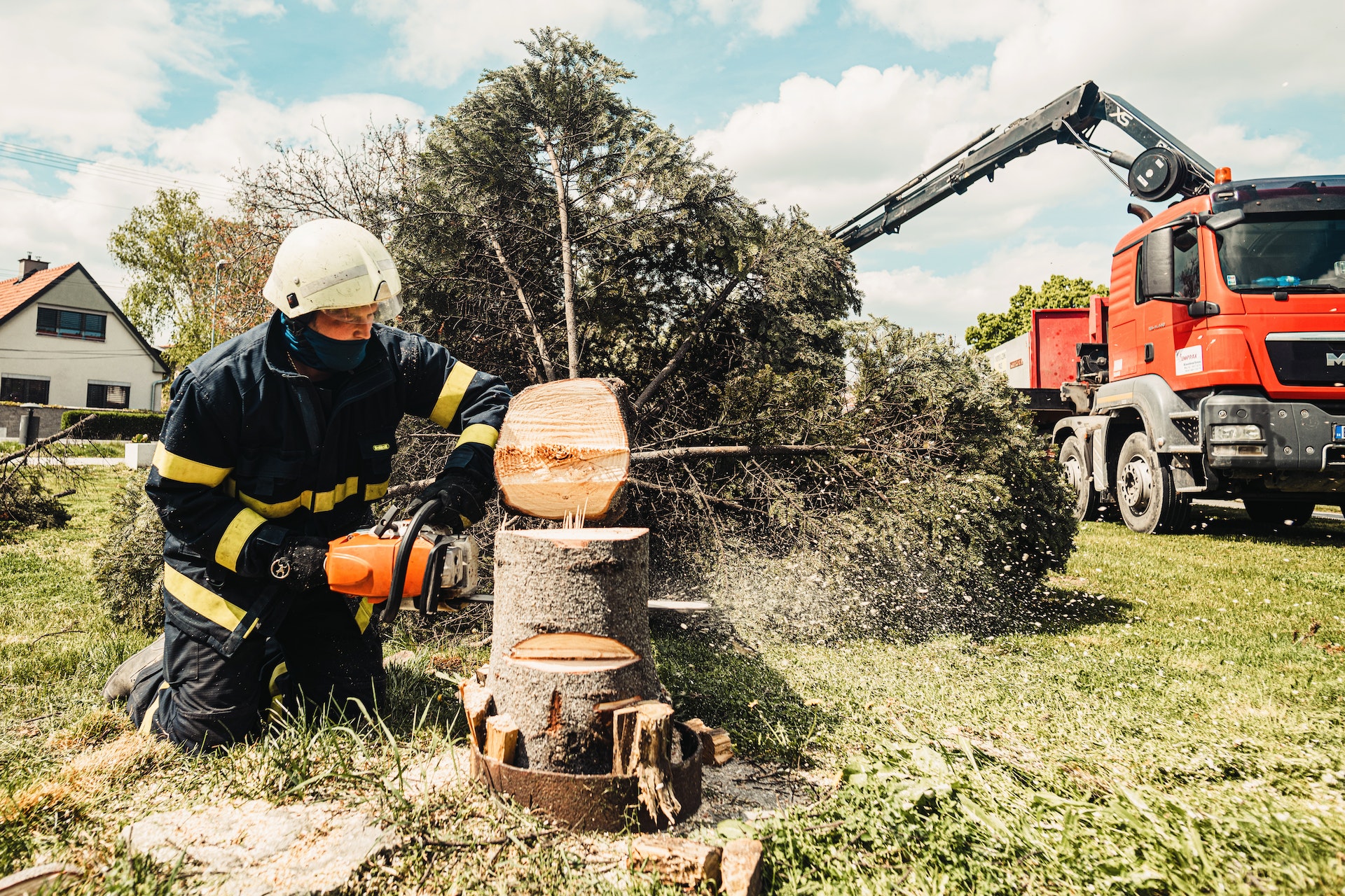 A Firefighter Cutting a Tree With a Chainsaw